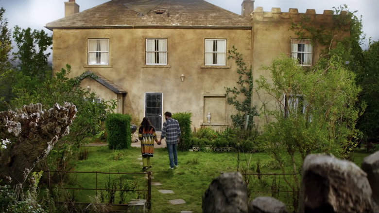 The young couple walk into their new country house