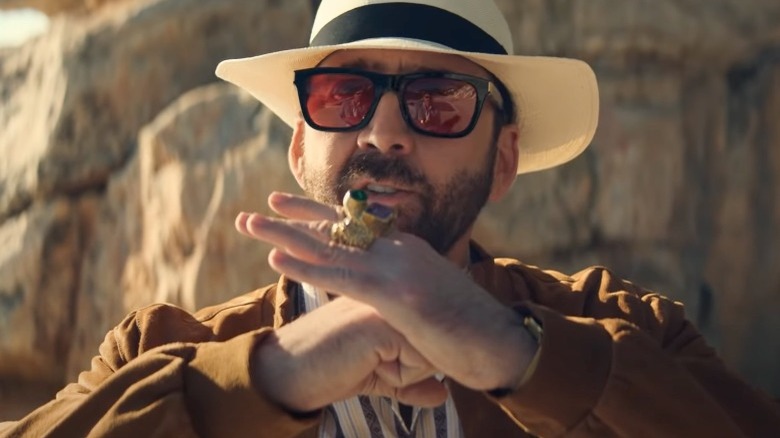 Nicholas Cage gestures in sunglasses