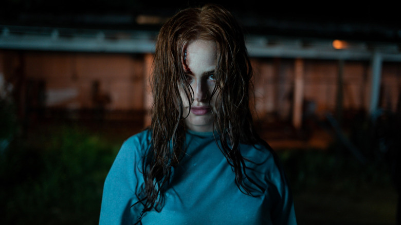 Madelaine Petsch as Maya Lucas in The Strangers: Chapter 2, looking grimly ahead with blood trickling down her forehead.