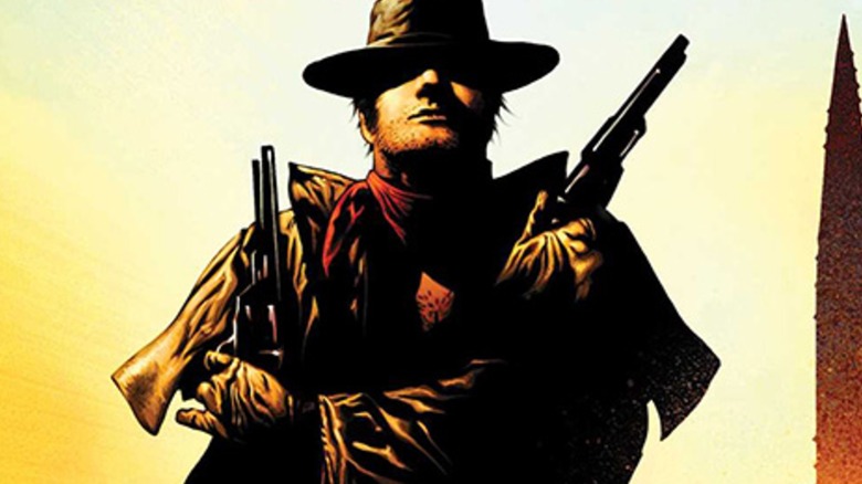 The gunslinger holds two guns, his face hidden in shadow, from the cover of a Dark Tower comic