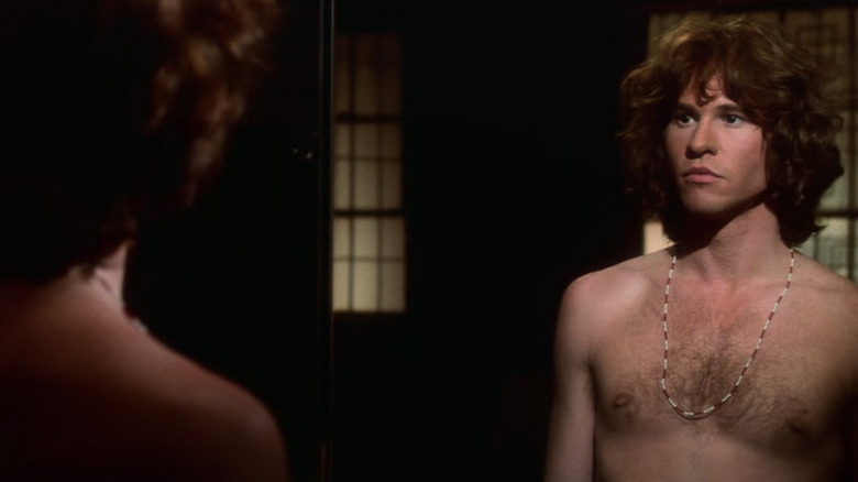 Val Kilmer gazes at his shirtless reflection as Jim Morrison in The Doors