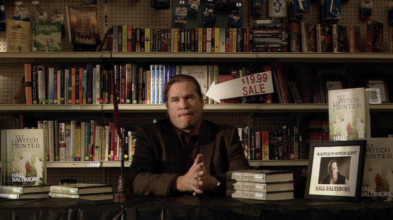 Val Kilmer's Hall Baltimore sits at a desk in a book store in Twixt