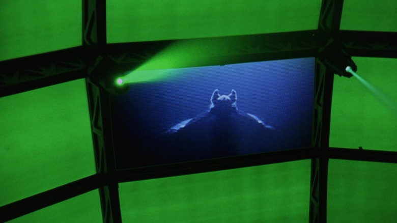 A bat flying towards camera is seen on a screen in Batman Forever