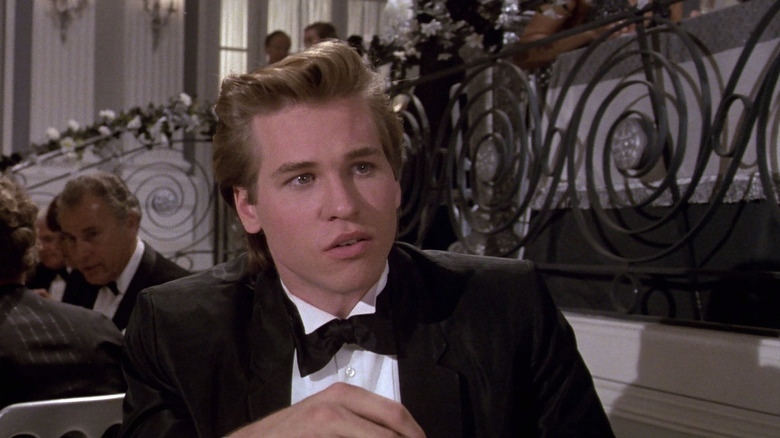 Val Kilmer as Nick Rivers sitting in a tuxedo in Top Secret!