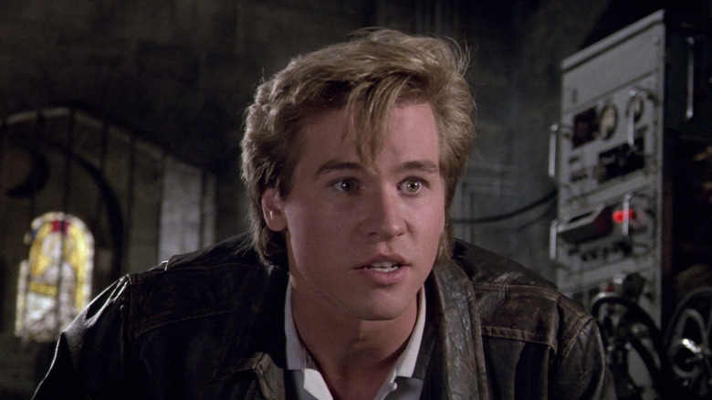 Val Kilmer as Nick Rivers wearing a leather jacket and looking alert in Top Secret!