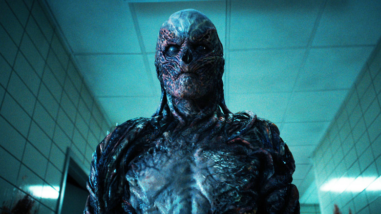 Jamie Campbell Bower's Vecna stand in a hallway in Stranger Things