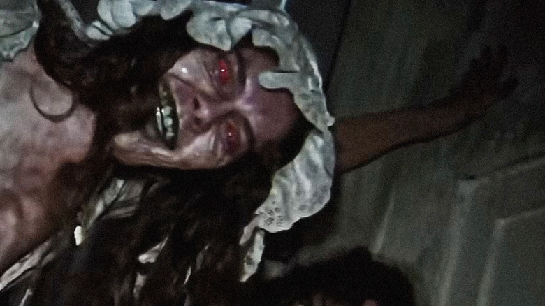 The mother grinning at the camera in the V/H/S/Halloween segment Coochie Coochie Coo