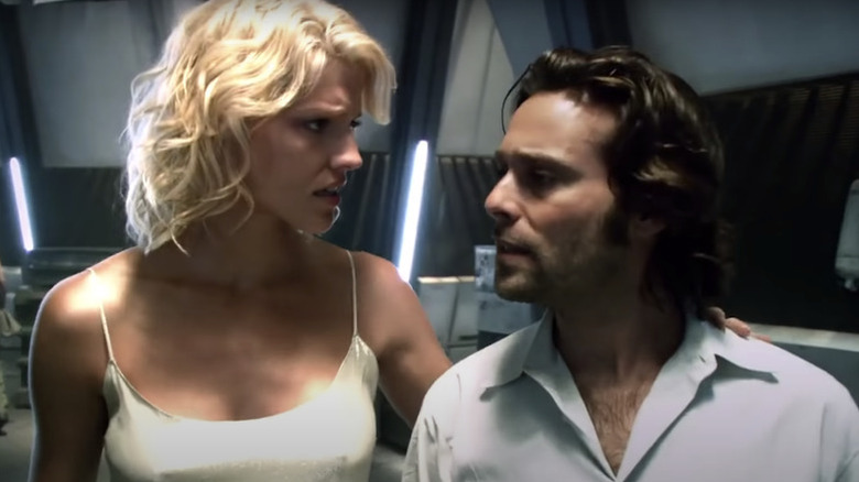 Head Six and Gaius Baltar walking in a hallway together in Battlestar Galactica