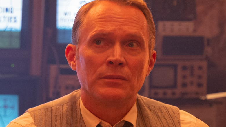Paul Bettany as Vision in his human avatar in front of several television screens in VisionQuest