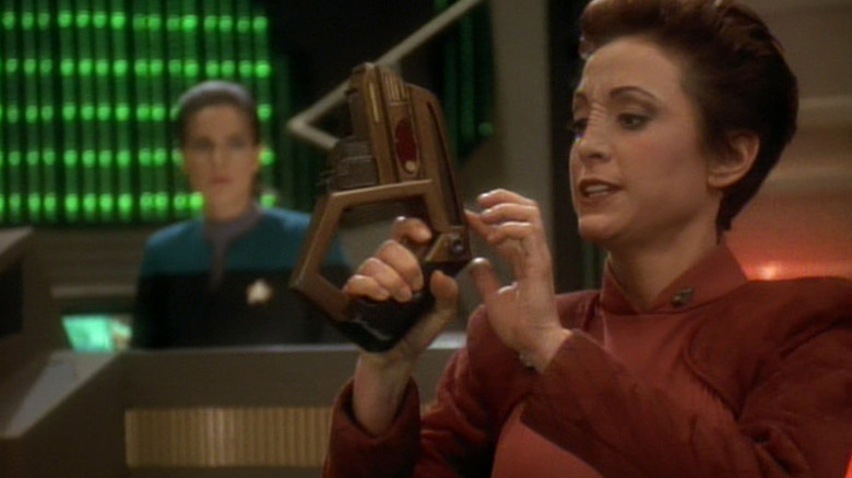 Kira holding a phaser with Dax in the background on Star Trek: Deep Space Nine