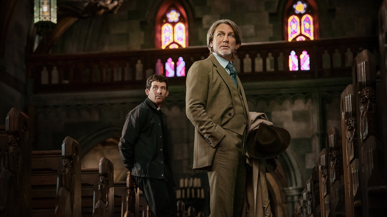 Daniel Craig as Benoit Blanc and a priest (Josh O'Connor) standing in a church in Wake Up Dead Man