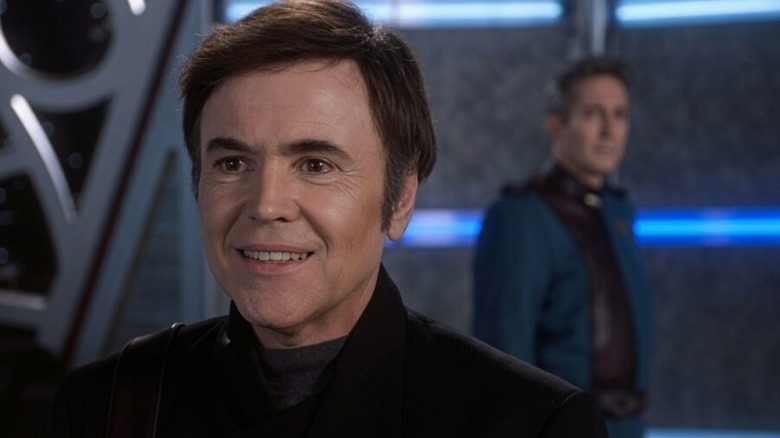 Babylon 5 - Alfed Bester smiling with Commander Jeffrey Sinclair in the background