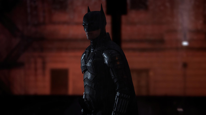 Robert Pattinson while Batman was drowned in the rain standing on the streets of Gotham in Batman
