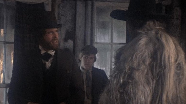McCabe talking to a man in a large furry coat in McCabe & Mrs. Miller