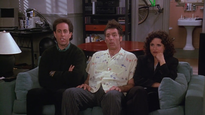 Jerry Seinfeld as Jerry, Michael Richards as Kramer, and Julia Louis-Dreyfus as Elaine sitting on a couch in Seinfeld