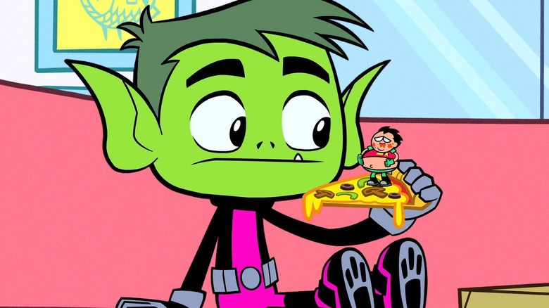 Beast Boy holding a slice of pizza with Robin on it in Teen Titans Go!