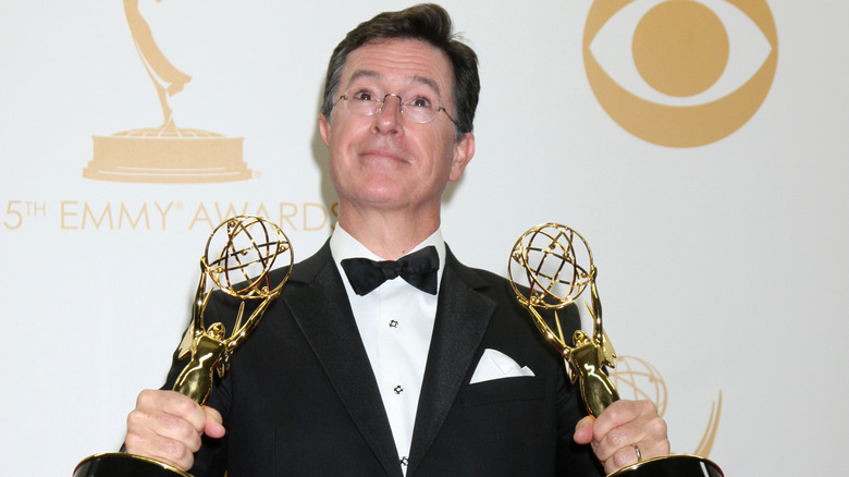 Stephen Colbert holding two of his Emmys