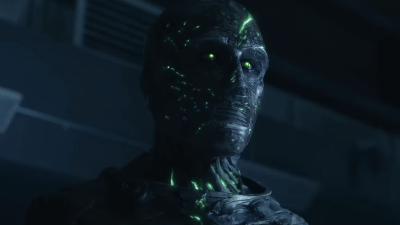 Toby Kebbell's Victor Von Doom stands in a dark room in Fantastic Four