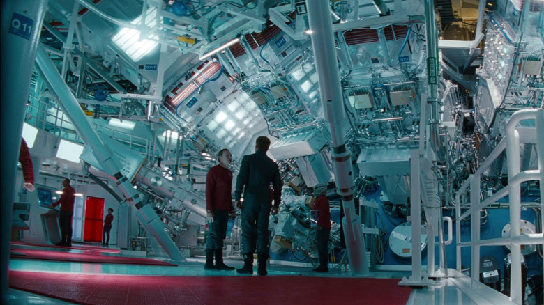 Simon Pegg as Scotty standing next to Chris Pine as Captain Kirk in front of the warp core in Star Trek Into Darkness