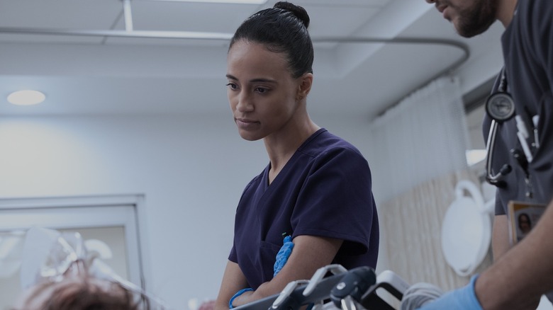 Dr. Garcia looking down at a patient on The Pitt