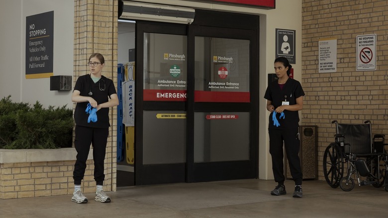 Mel and Mohan standing in the ambulance bay on The Pitt