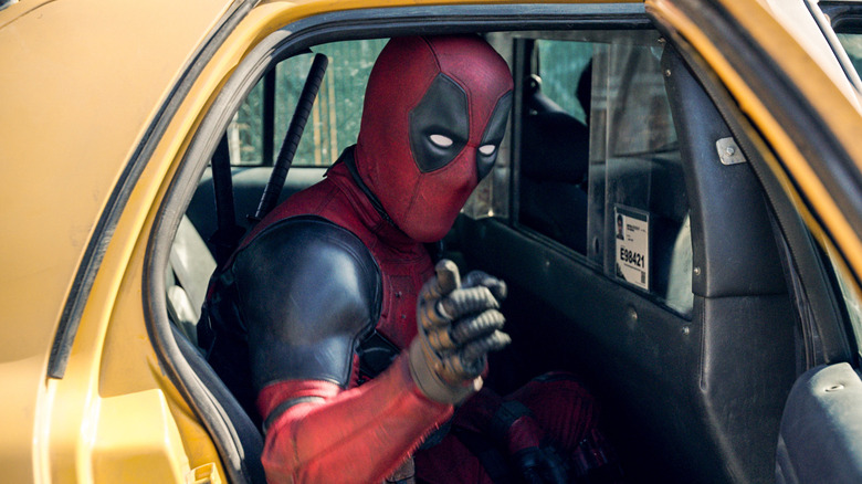 Ryan Reynolds as Deadpool pointing at the screening sitting in the cab in Deadpool