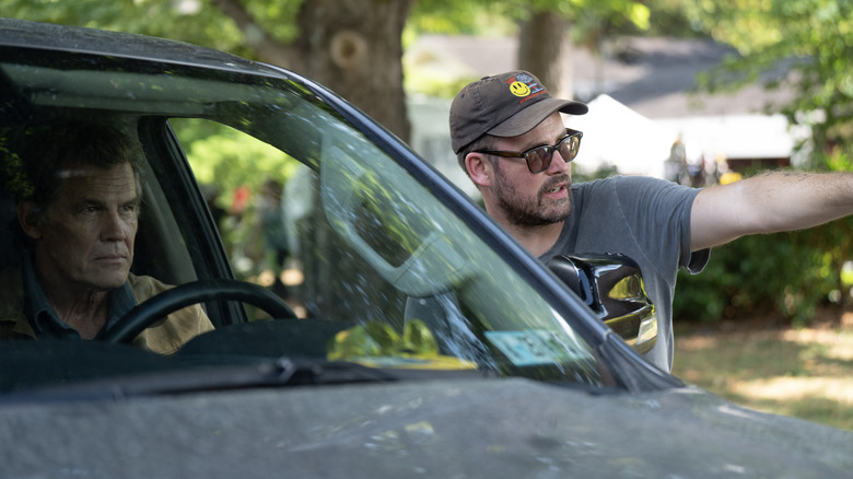 Josh Brolin sits in a truck while Zach Cregger directs him on the set of Weapons