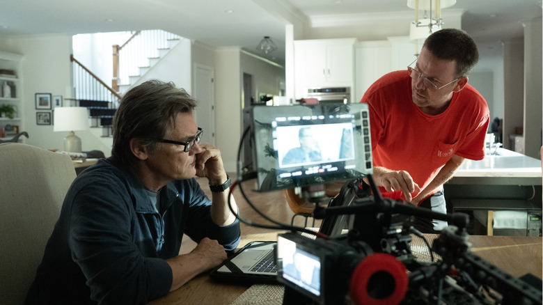 Josh Brolin sitting at a computer in front of a camera with director Zach Cregger on the set of Weapons
