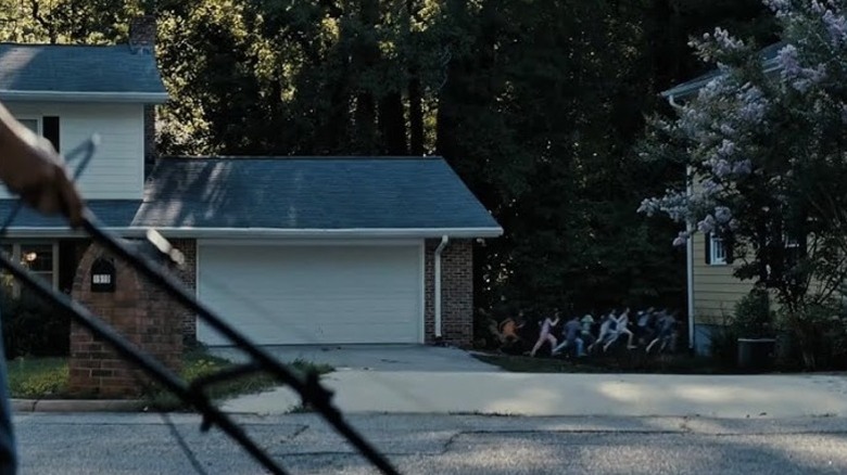 A crowd of kids chasing Gladys through people's lawns in Weapons