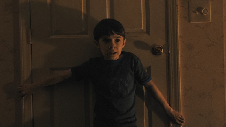 Alex holding a door shut in Weapons