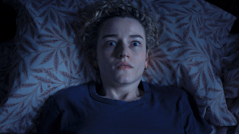 Julia Garner as Justine Gandy looking alarmed in bed in Weapons