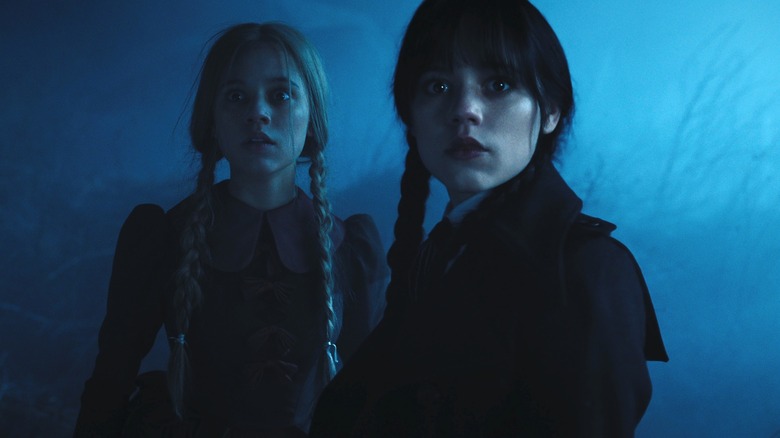 Wednesday and Goody Addams seem disturbed by something offscreen in Wednesday