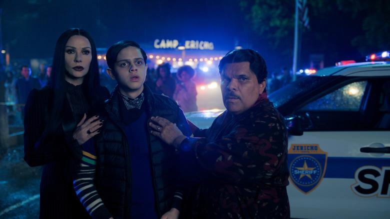 Catherine Zeta-Jones as Morticia Addams, Isaac Ordonez as Pugsley Addams, and Luis Guzmán as Gomez Addams looking alarmed in Wednesday