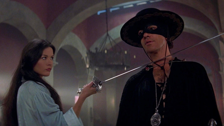 Catherine Zeta-Jones as Elena points her sword at Antonio Banderas as Alejandro Murrieta's neck in The Mask of Zorro