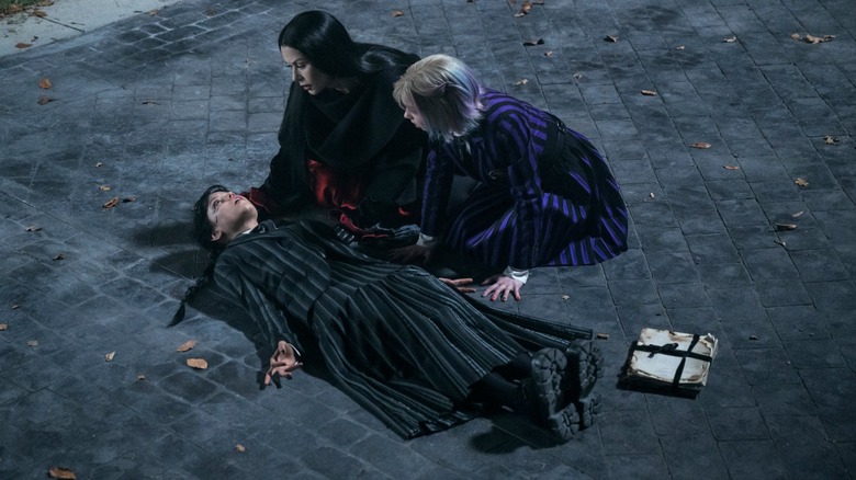 Wednesday experiences a vision as Morticia and Enid look on in Wednesday