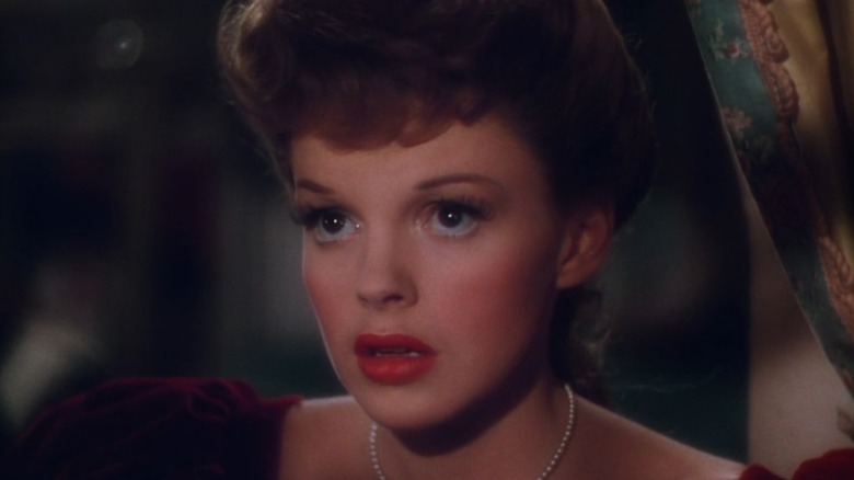 Judy Garland's Esther, in full makeup, looks longingly into the night in Meet Me In St. Louis