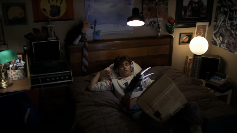 Johnny Depp as Glen Lantz lays on a bed as a hand emerges from the mattress in A Nightmare on Elm Street