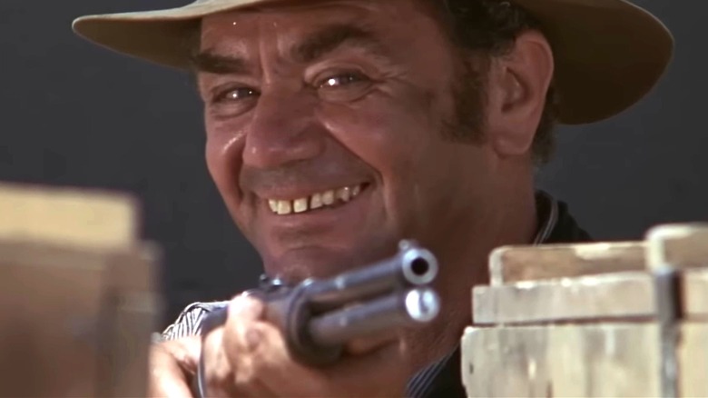 Ernest Borgnine's "Dutch" Engstrom smiles as he aims a rifle in The Wild Bunch