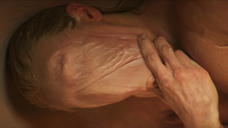 Tom Rhys Harries as Matt Hagen with his skin melted over his face in the bathtub in Clayface