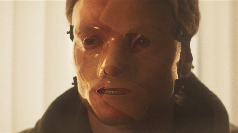 Tom Rhys Harries as Matt Hagen with his mask covering the scars on his face in Clayface