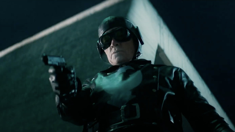 Thomas Haden Church as Lobster Johnson holding a gun in the rain in Hellboy (2019)