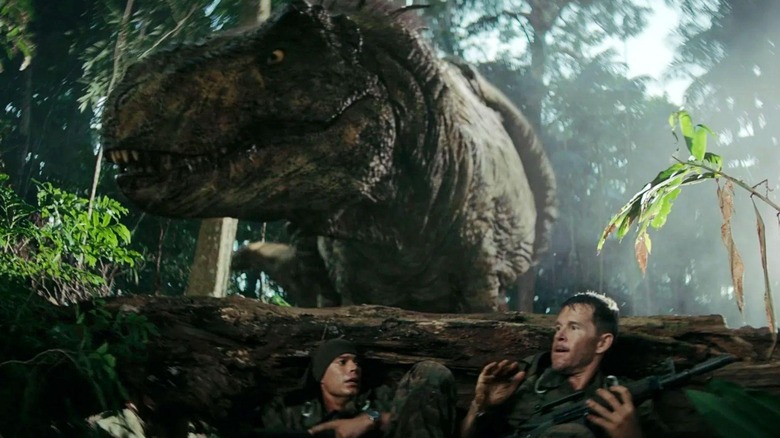 Baker and Leon hiding behind a log from a T-rex in Primitive War