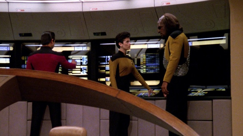 స్టార్ ట్రెక్: ది నెక్స్ట్ జనరేషన్‌లో ఎంటర్‌ప్రైజ్-డిలో వెనుక కంప్యూటర్ కన్సోల్‌ల ముందు నిలబడి ఉన్న వోర్ఫ్ మరియు మరొక అధికారి