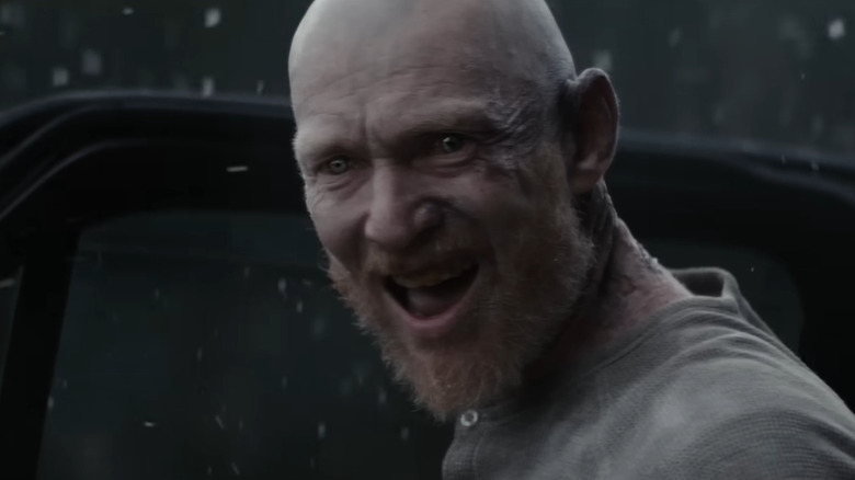 Erroll Shand as Edgar standing by the car door in the snow in Evil Dead Burn