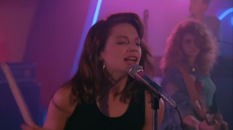 Jennie singing into a microphone in Satisfaction