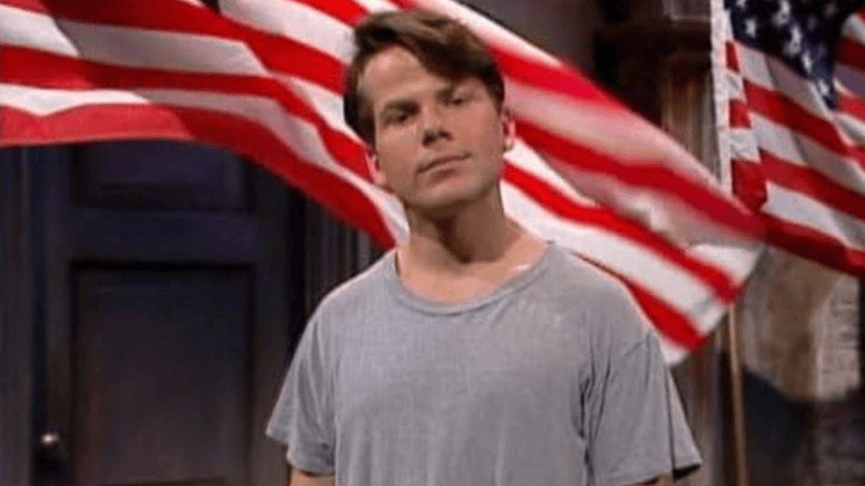 Bruce McCulloch in front of American flags on Kids in the Hall