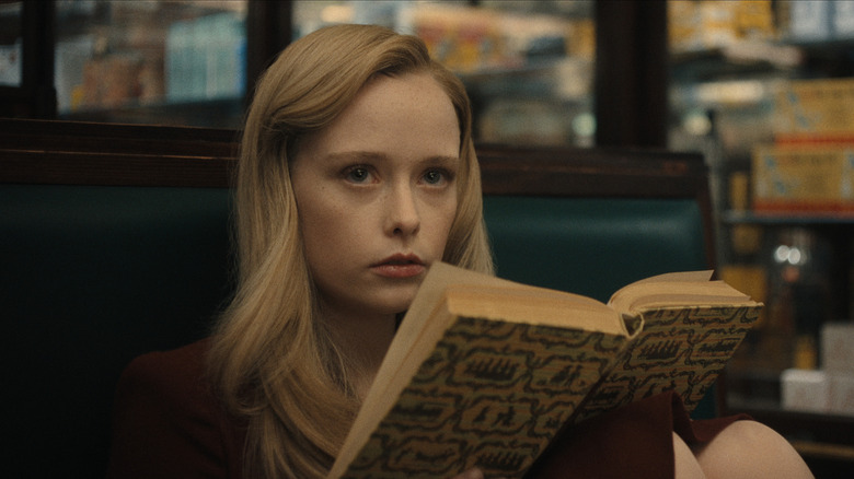 Suzanna Son as Adelina reading a book in Monster: The Ed Gein Story