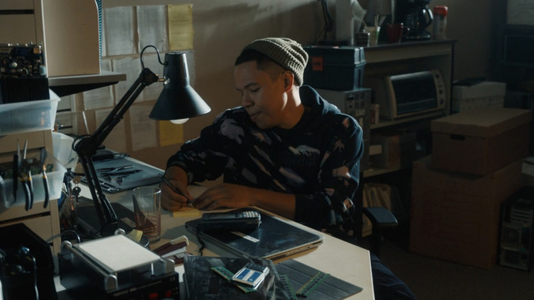 Eric Grogage while Bobby Exley seated at his office by writing on a pad in Tracker
