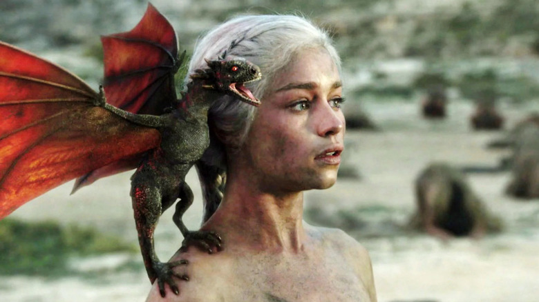 Emilia Clarke as Daenerys Targaryen with little baby Drogon on her shoulder