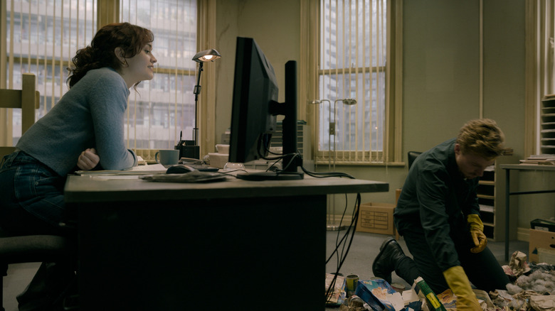 Olivia Cooke's Sid Baker watches Jack Lowden's River Cartwright sifting through trask on the floor of his office in Slow Horses